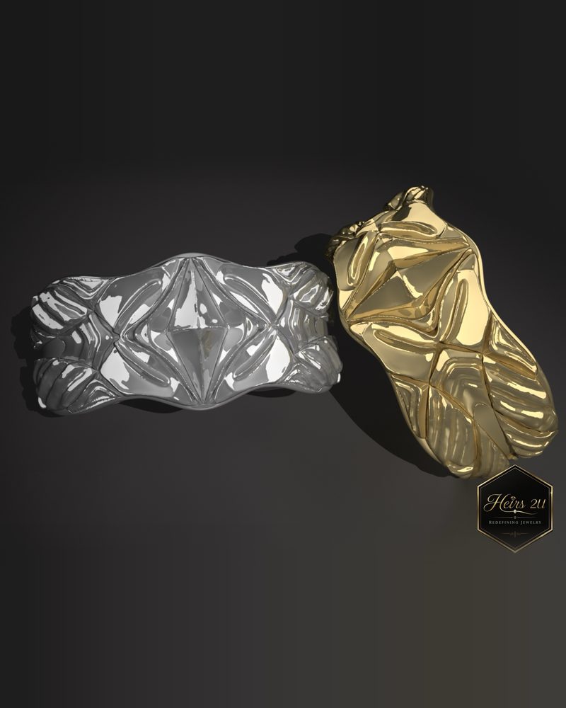 Two sculpted bracelets side by side, one white metal and one yellow gold, with a carved relief pattern