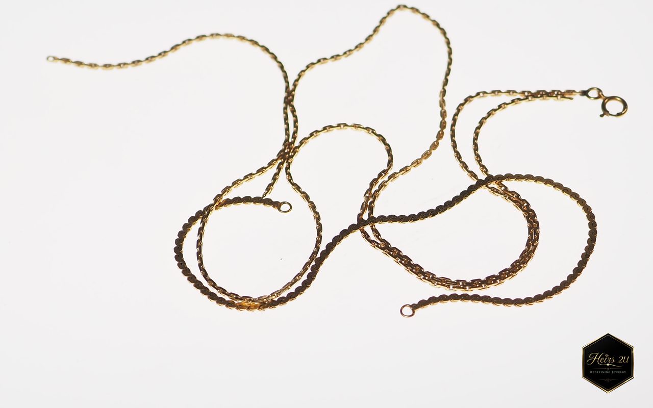 Gold rope chains laid loosely on a white surface