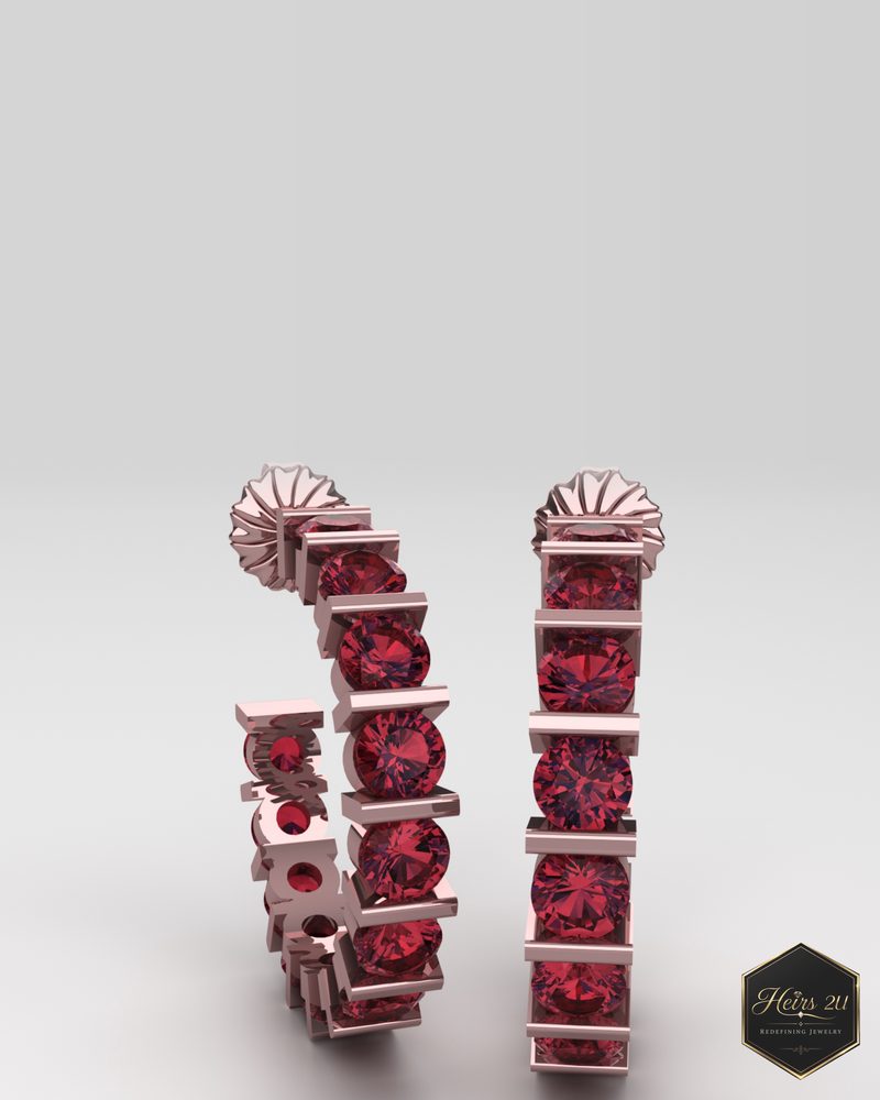 A pair of rose gold hoop earrings with red stones held in a row of bar settings