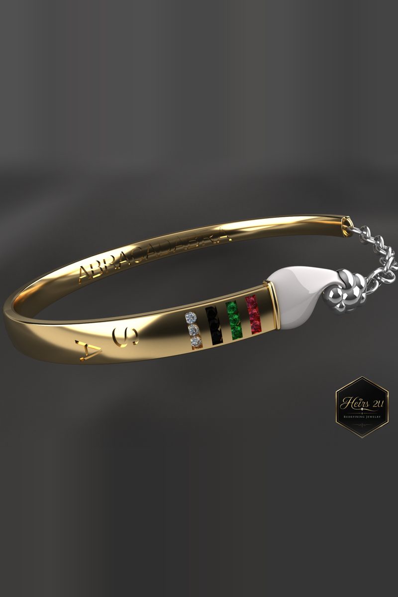 The Curved Paintbrush Bracelet — a gold cuff inlaid with bands of colour, with a white brush-tip end and a chain