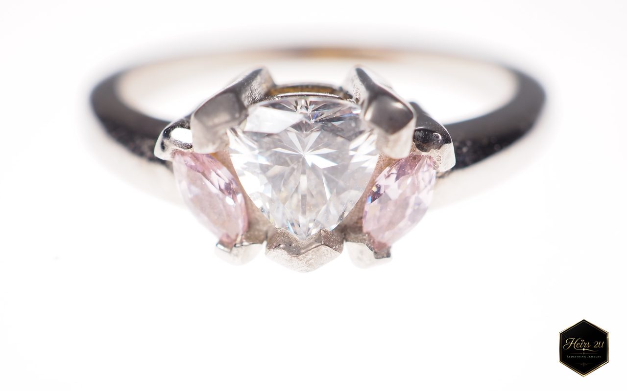 A ring with a large clear trillion-cut centre stone flanked by two pink marquise stones