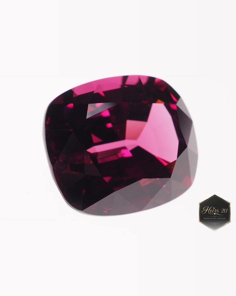 A cushion-cut pink-red Umba garnet photographed close up at an angle