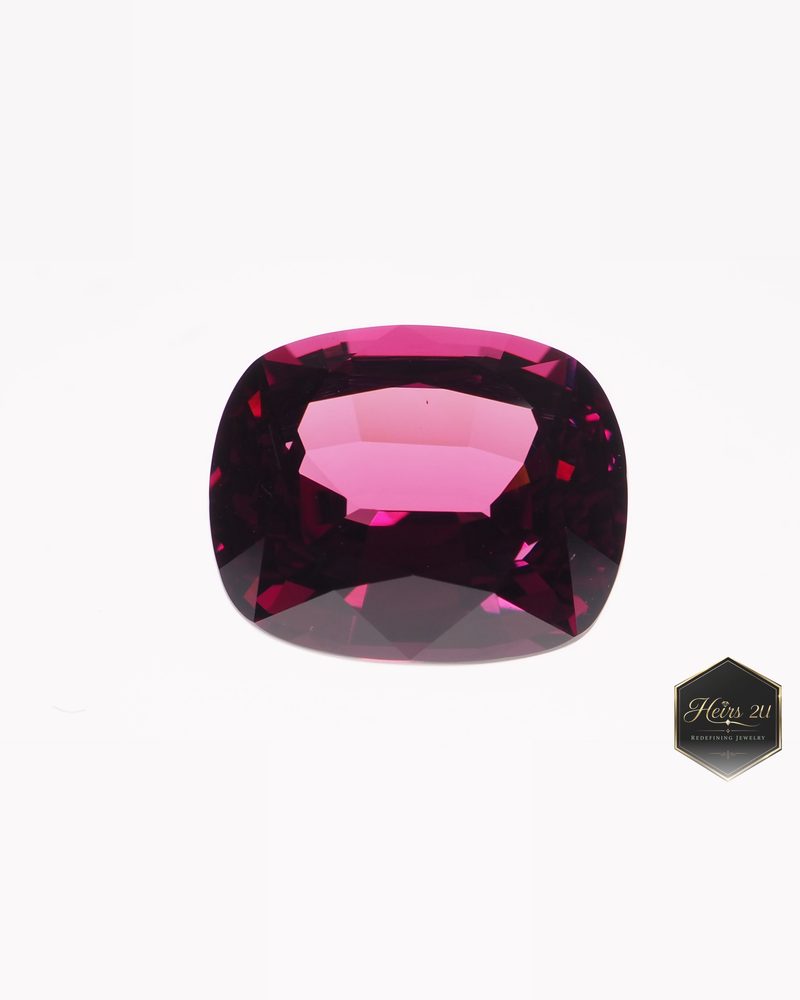 A cushion-cut pink-red Umba garnet photographed face up on white
